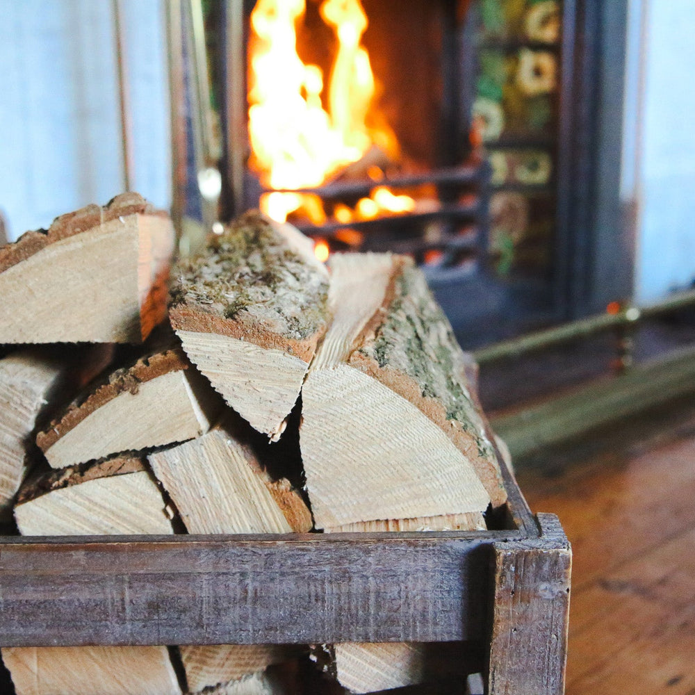 Hardwood logs piled in front of an open fire