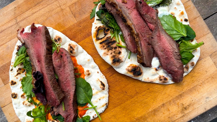 Homemade flatbreads topped with spicy mayo, salad and picanha steak