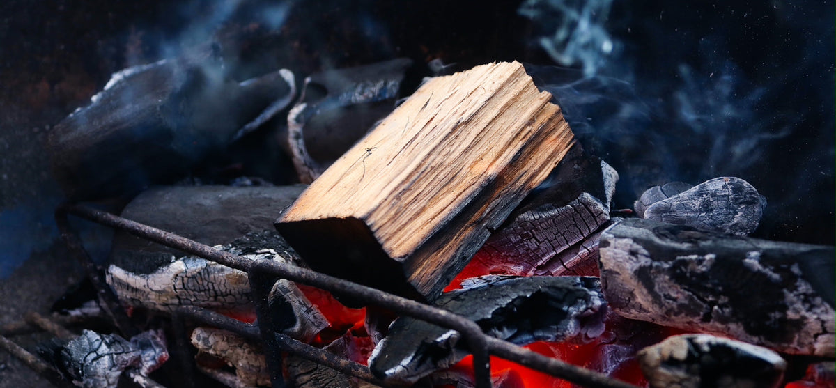 Wood chunk smoking on lumpwood charcoal