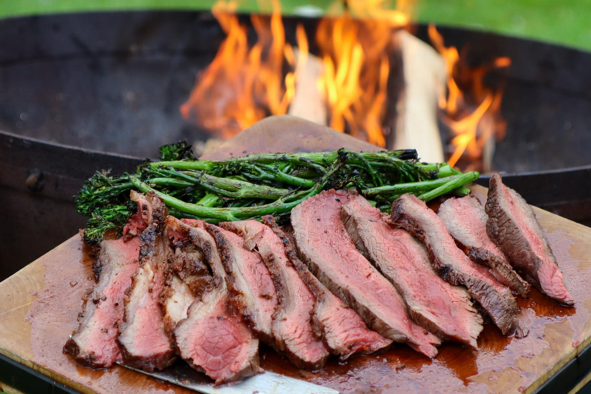 Medium rare picanha steak in front of a Kadai fire bowl