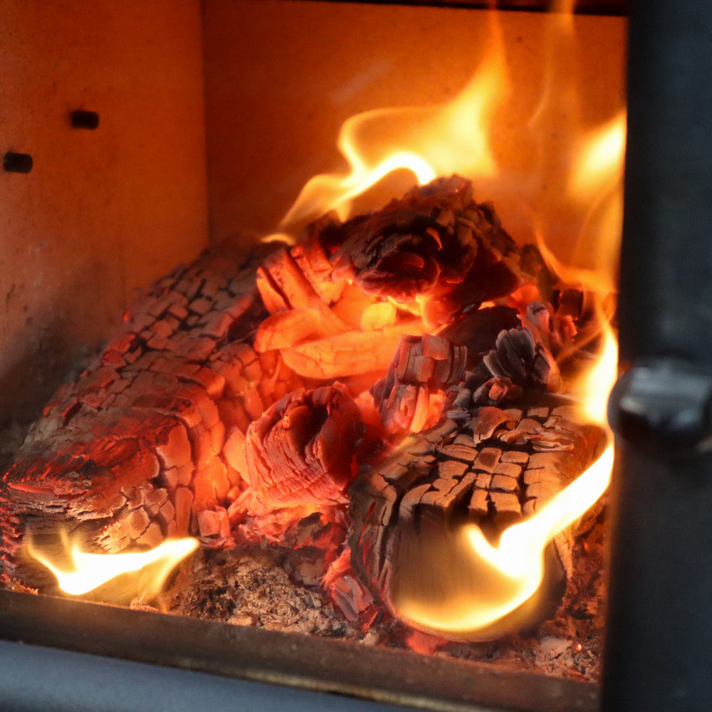 Love Logs kiln-dried firewood burning down to embers in log burner