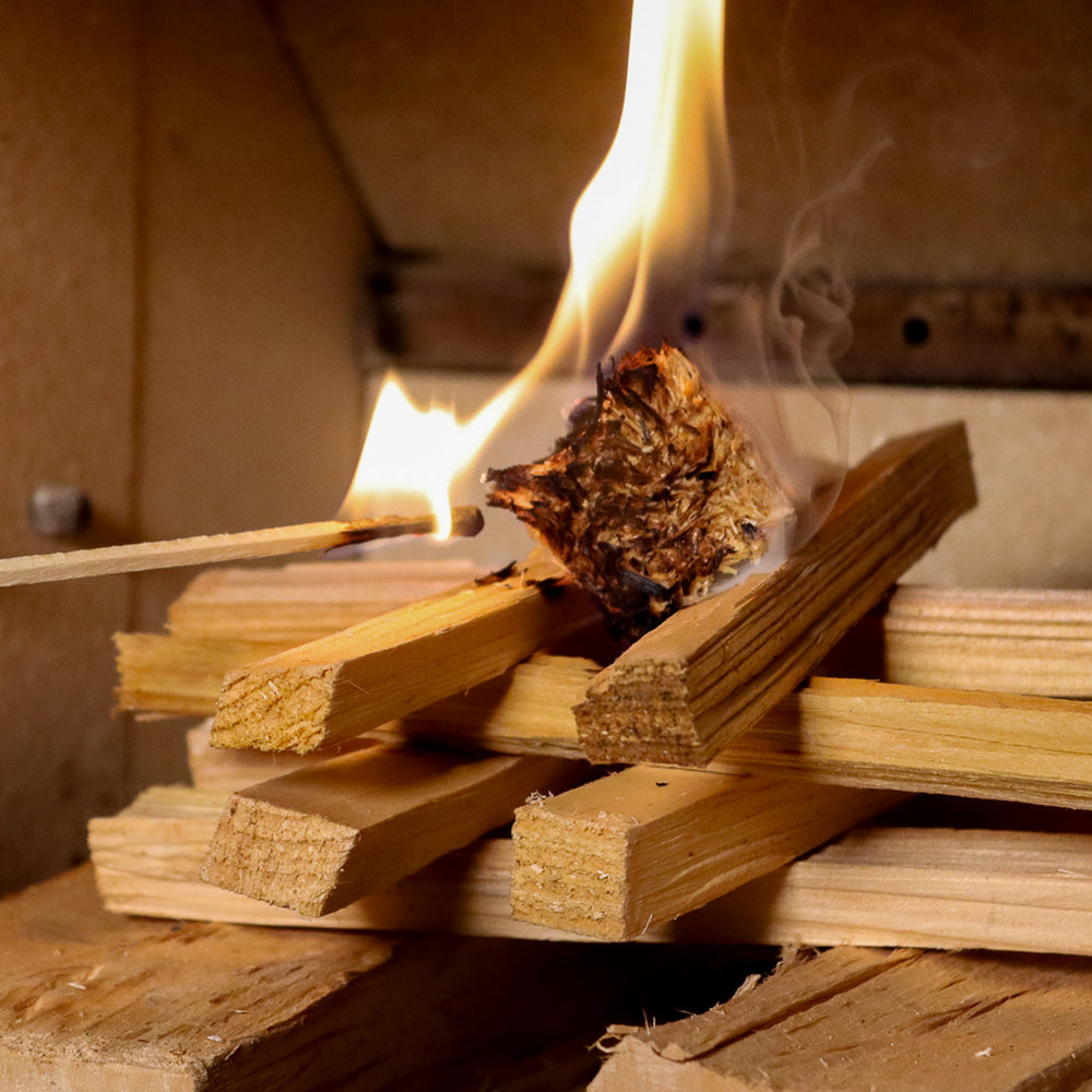 Love Logs natural firelighter being lit by a Love Logs extra long match