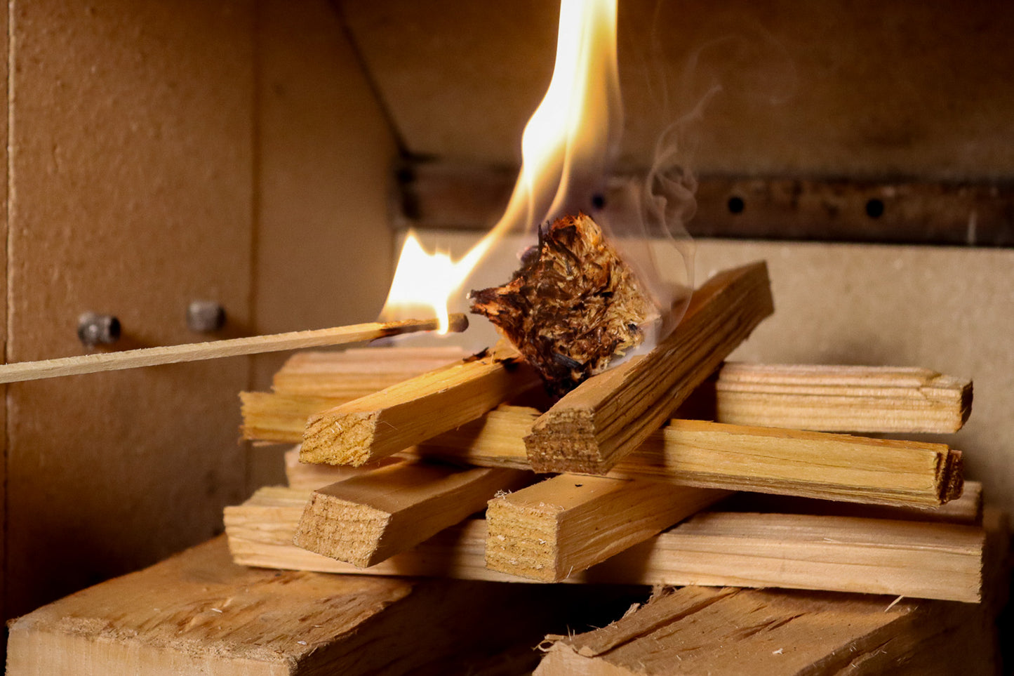 Love Logs natural firelighter being lit by a Love Logs extra long match