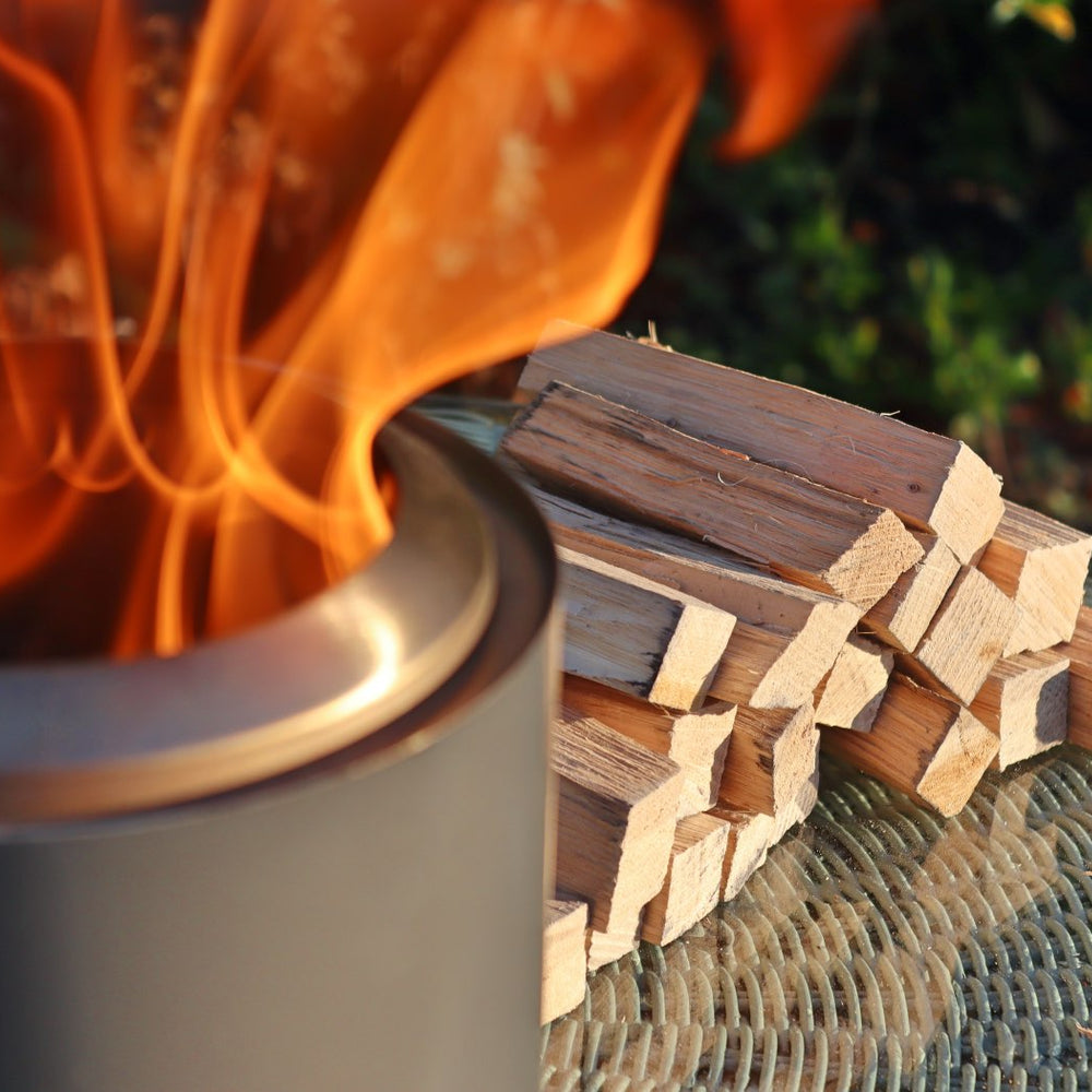 
                      
                        Love Logs Mini Fire Pit Wood burning cleanly in Mesa XL with wood stacked in the background
                      
                    