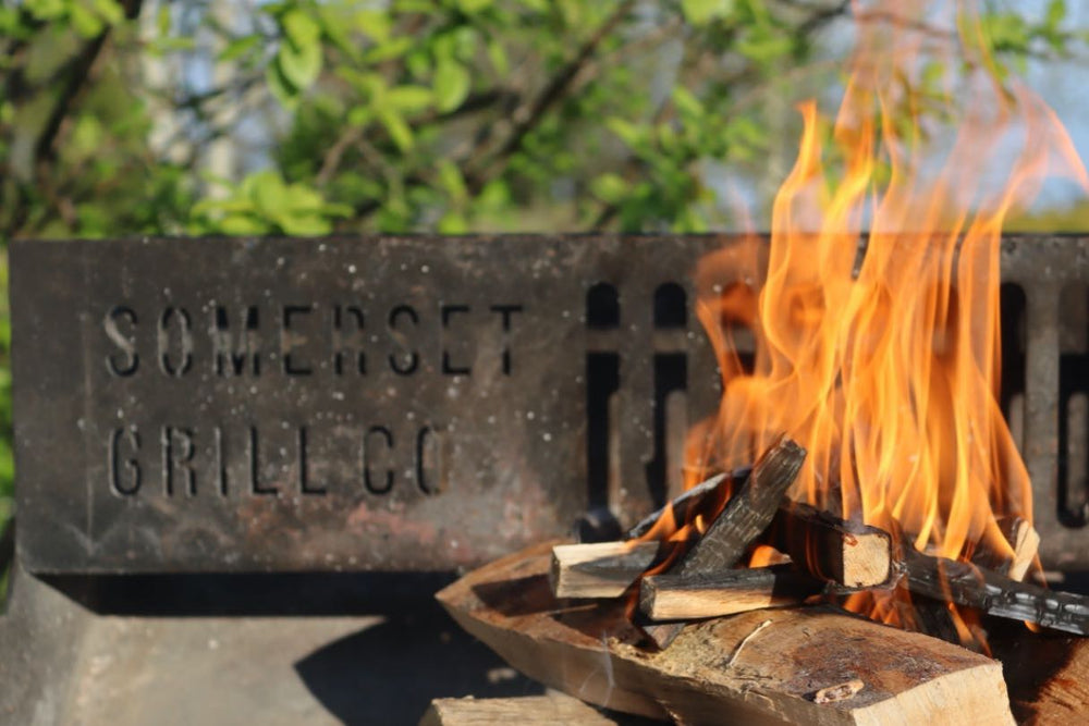 Beech logs burning in a Somerset Grill Co Asado Grill
